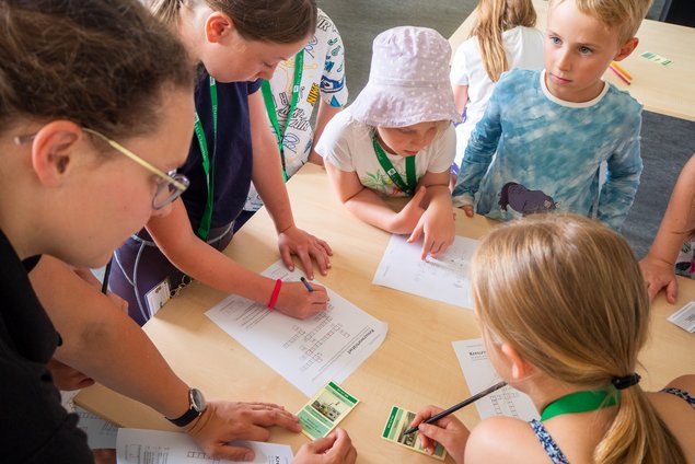 Kinder schauen auf Zettel